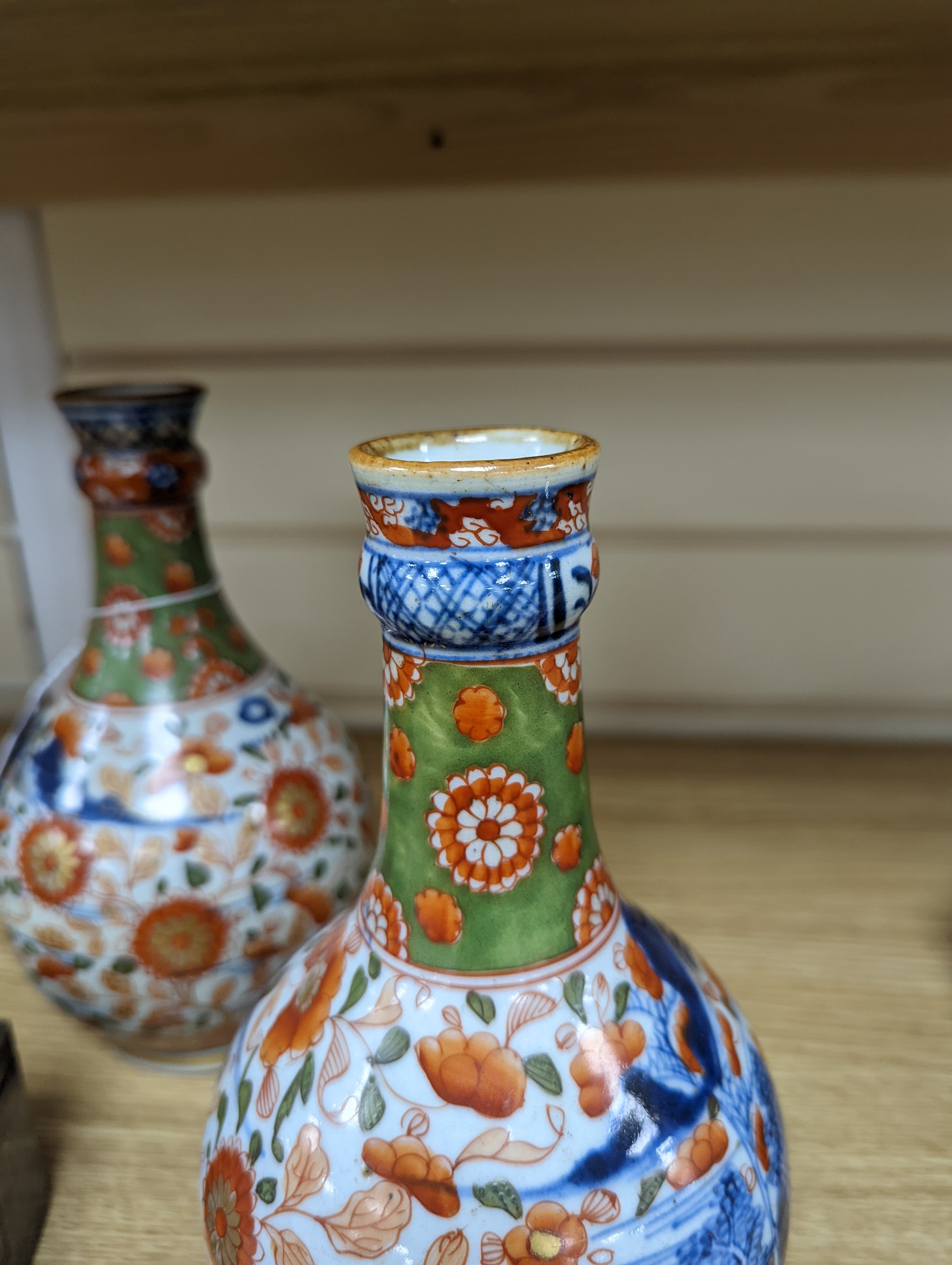 A pair of 18th century Chinese clobbered blue and white bottle vases 23cm